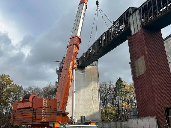 Mobilní jeřáb Liebherr LTM 1500 při manipulaci s ocelovou konstrukcí dopravníkového mostu.